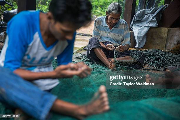 Burmese fishermen mend nets in their village near the planned Dawei SEZ on August 4, 2015 in Pantininn, Myanmar. The controversial, multi-billion...