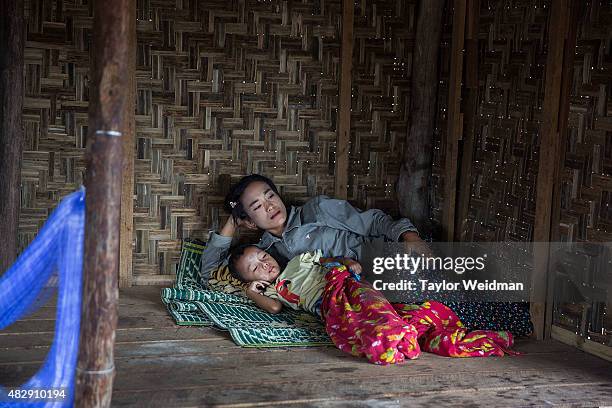 Burmese woman rests with her son in a seafood sorting area near the planned Dawei SEZ on August 4, 2015 in Maungmagan, Myanmar.The controversial,...
