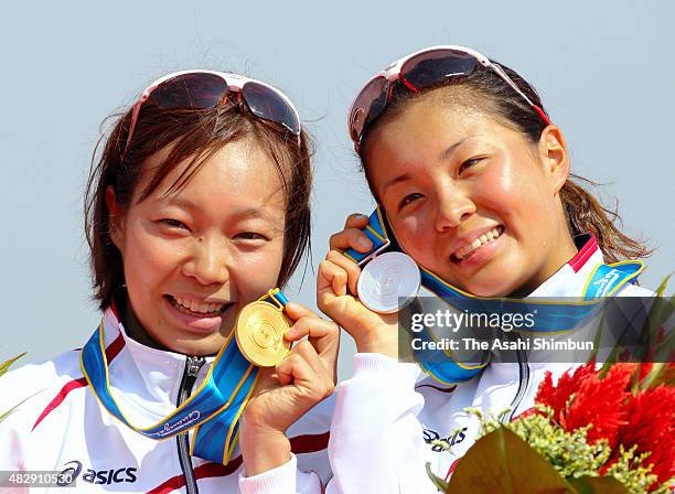 Gold medallist Mariko Adachi and silver medallist Akane Tsuchihashi of Japan pose for photographs at the medal ceremony for the Women's Triathlon...