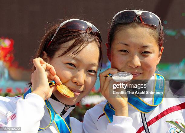 Gold medallist Mariko Adachi and silver medallist Akane Tsuchihashi of Japan pose for photographs at the medal ceremony for the Women's Triathlon...