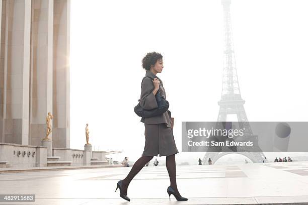 femme d'affaires marchant sur la plaza de la tour eiffel - sac à main blanc photos et images de collection