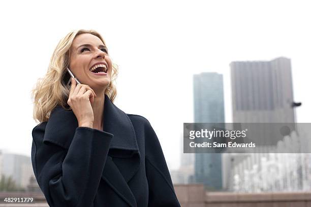 woman outdoors using cellular phone - feature phone stockfoto's en -beelden