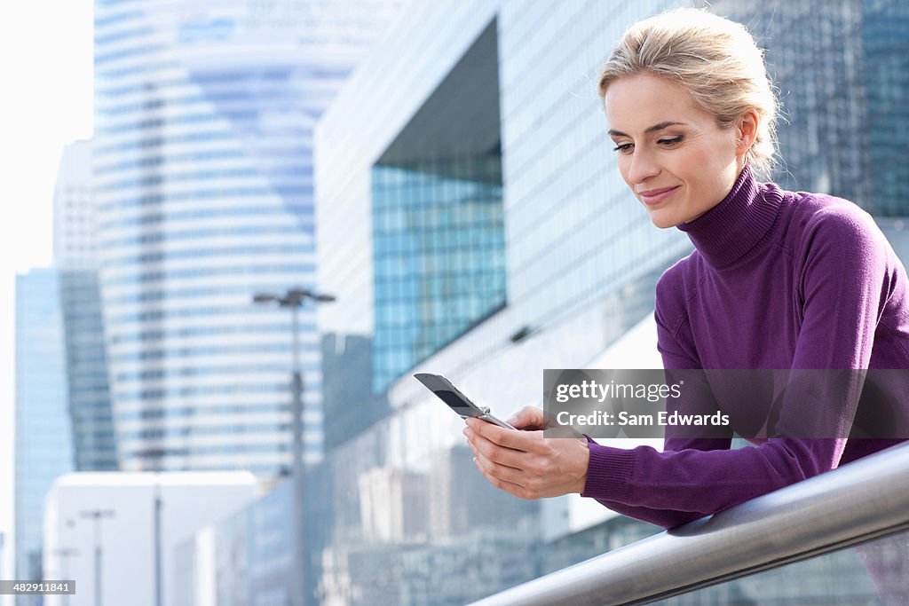 Mulher em pé na varanda com telefone Celular