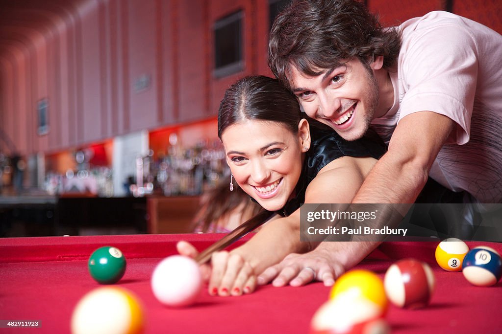 Couple playing pool and smiling