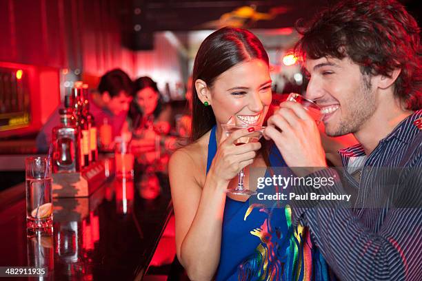 souriant couple dans la discothèque avec boissons - bar tender photos et images de collection