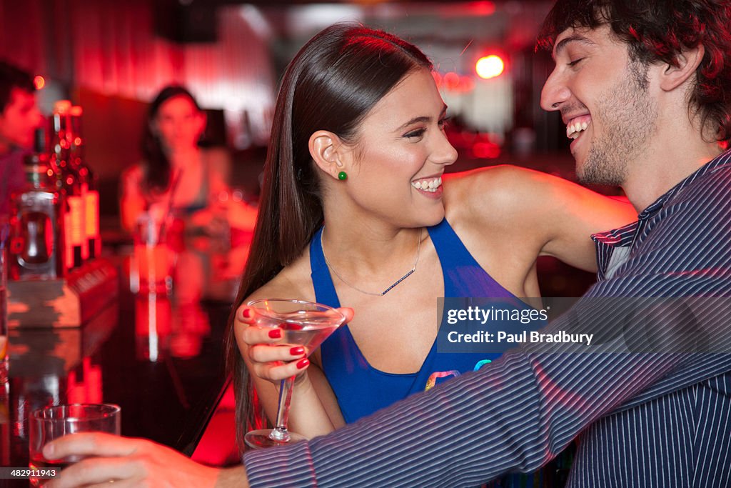 Smiling couple in nightclub with beverage