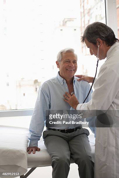 arzt mit stethoskop auf lächelnd patient - adult patient with doctor and stethoscope stock-fotos und bilder