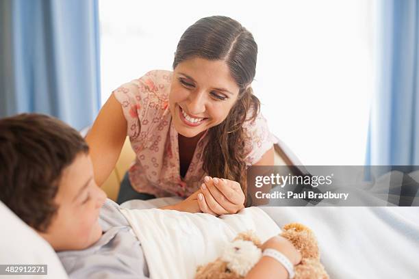 menino dormindo na cama de hospital com urso de pelúcia - mama bear - fotografias e filmes do acervo