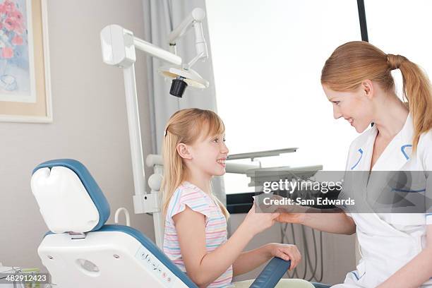 assistente dentista con giovane paziente con vetro - dentista bambini foto e immagini stock