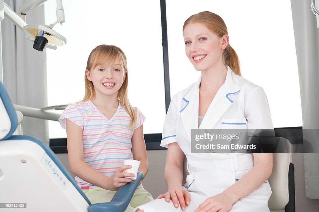 Zahnarzthelfer mit jungen Patienten hält Glas