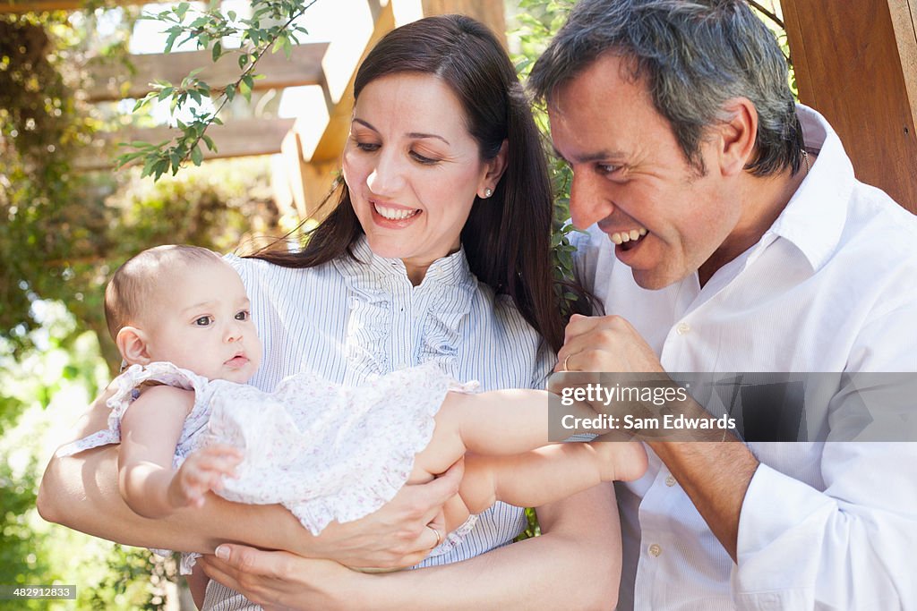 Couple outdoors with baby smiling