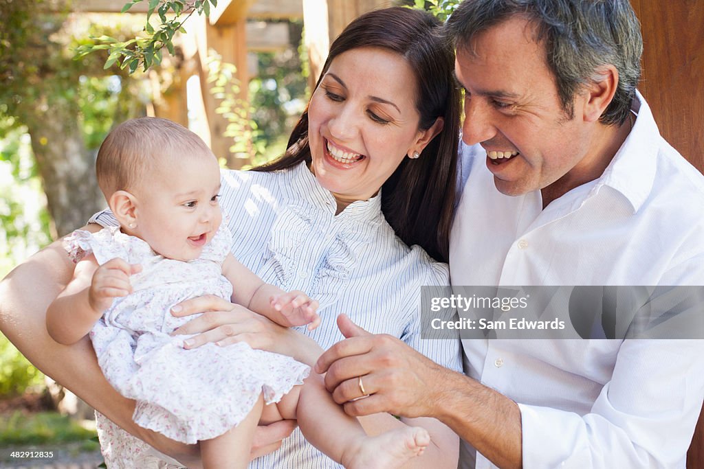 Couple outdoors with baby smiling