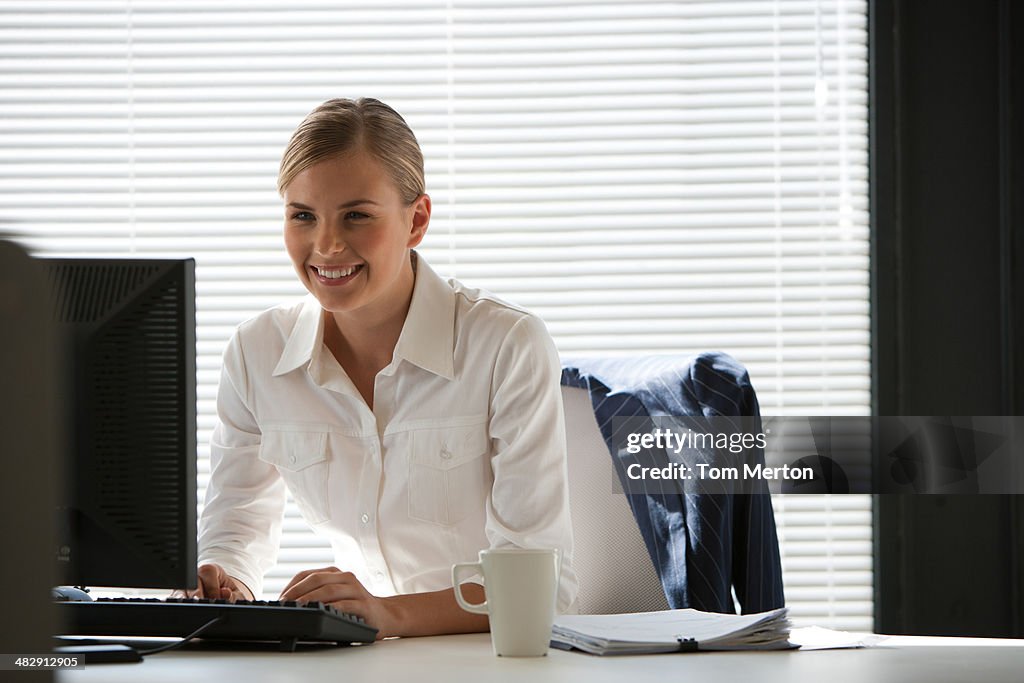Mulher de negócios na mesa com o computador