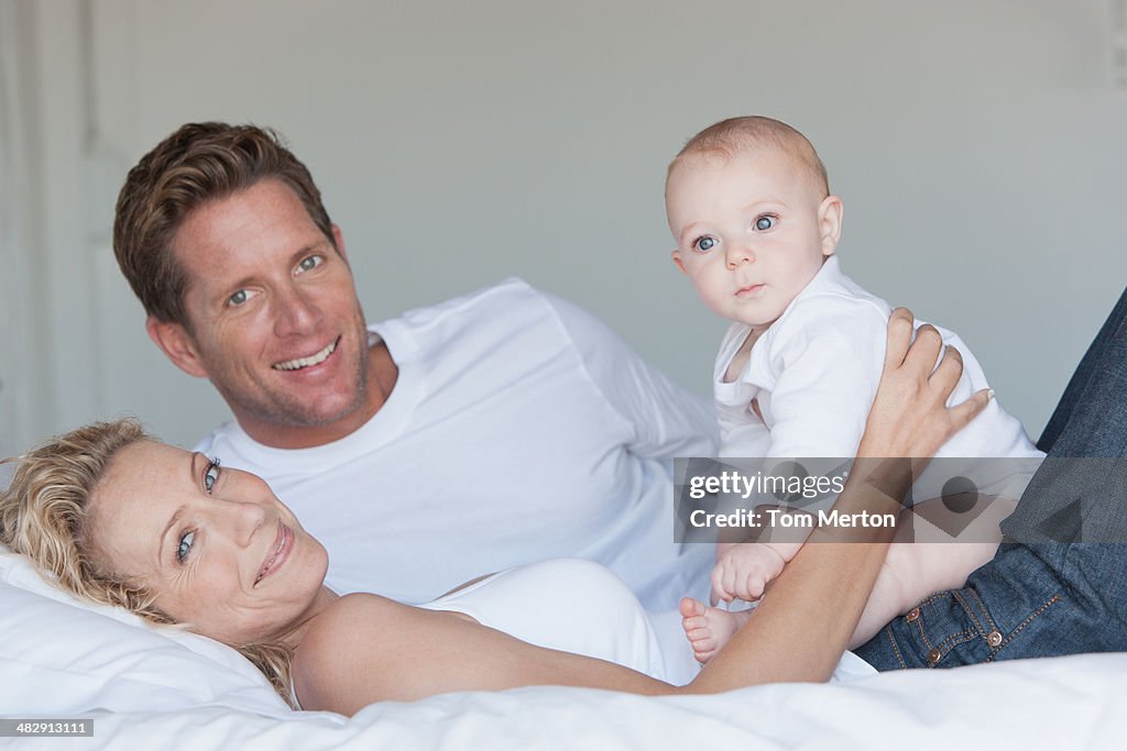 Man and woman in bed with baby