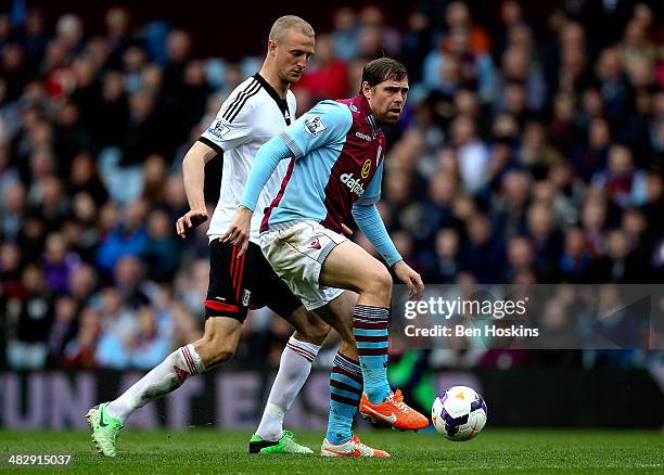 Grant Holt of Aston Villa holds off pressure from Brede Hangeland of Fulham during the Barclays Premier League match between Aston Villa and Fulham...
