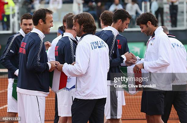 Ross Hutchins of Great Britain swaps pennants with Simone Bolelli of Italy during day two of the Davis Cup World Group Quarter Final match between...