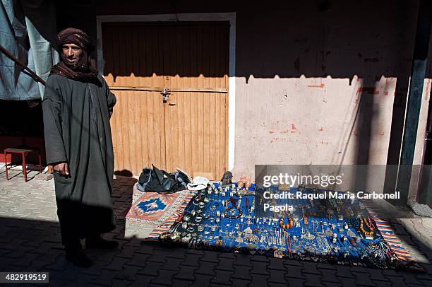 Man in traditional clothing at his Berber jewellery street stall.