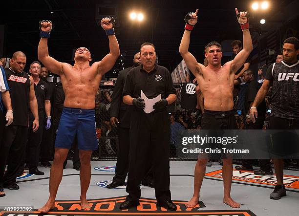 Vicente Luque and Hayder Hassan raise their hands as they wait for the judges decision after their three round fight during the filming of The...