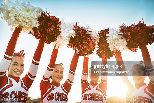 glück cheerleader posieren mit pon-pan und arme hoch - pom pom stock-fotos und bilder