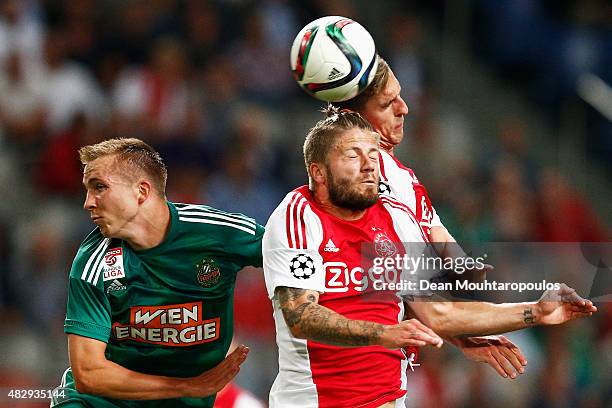 Lasse Schone and Arkadiusz Milik of Ajax challenges for the headed ball with Christopher Dibon of Rapid Wien during the third qualifying round 2nd...