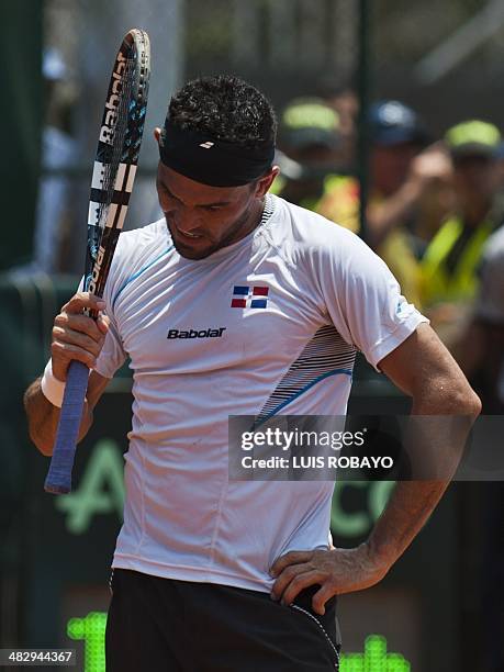 Dominican Republic's tennis player Victor Estrella reacts after losing a point to Colombian tennis players Juan Sebastian Cabal and Robert Farah...