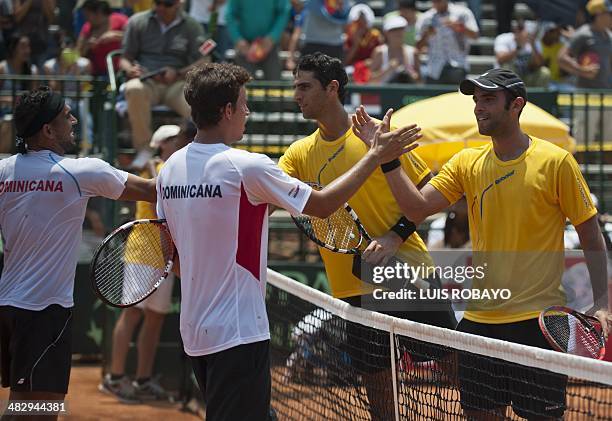 Dominican Republic's tennis player Victor Estrella and his teammate Jose Hernandez shake hands with Colombian tennis players Robert Farah and Juan...