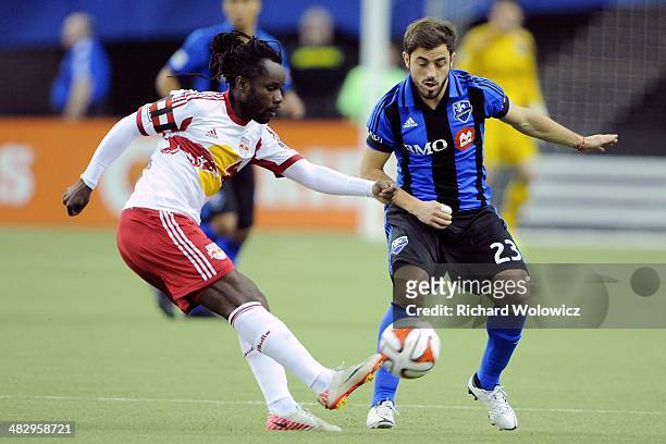 Peguy Luyindula of the New York RedBulls kicks the ball in front of Hernan Bernardello of the Montreal Impact during the MLS game at the Olympic...