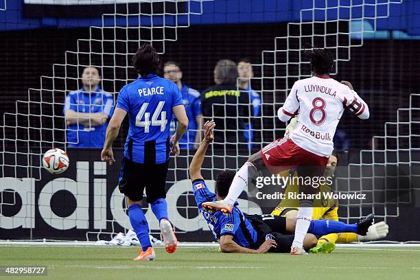 Peguy Luyindula of the New York RedBulls kicks the ball past Troy Perkins of the Montreal Impact to score during the first half of the MLS game at...