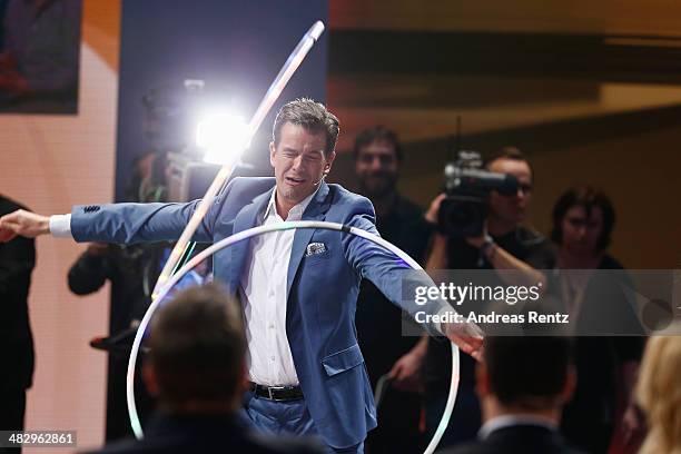 Host Markus Lanz perfoms with a hula hoop during the 'Wetten, dass..?' tv show on April 5, 2014 in Offenburg, Germany.