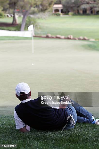 Former NHL player Wayne Gretzky lies on the 18th green during Aria Resort & Casino's 13th Annual Michael Jordan Celebrity Invitational at Shadow...
