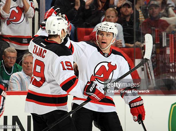 Travis Zajac of the New Jersey Devils celebrates his second-period goal against the Carolina Hurricanes with teammate Marek Zidlicky during their NHL...