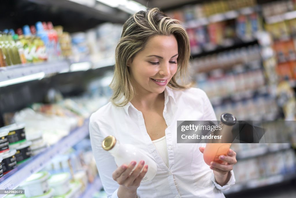 Shopping woman comparing products at the supermarket