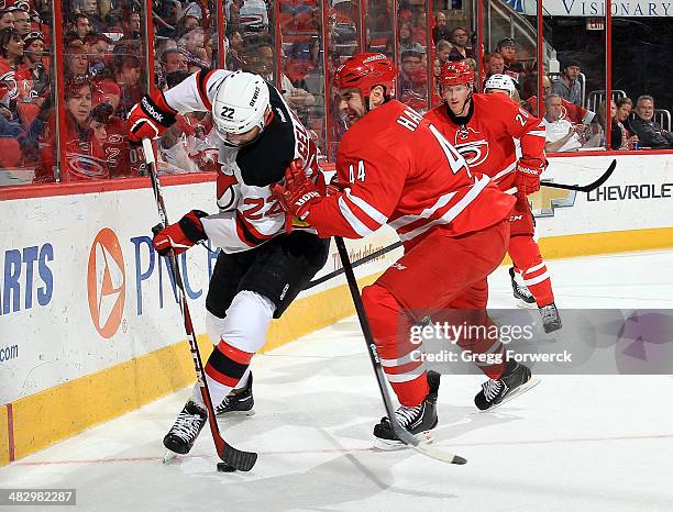 Jay Harrison of the Carolina Hurricanes linesup to check Eric Gelinas of the New Jersey Devils during their NHL game at PNC Arena on April 5, 2014 in...