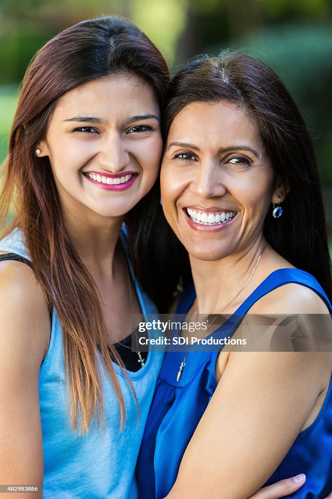 Beautiful young adult and mature Hispanic women smiling while outdoors