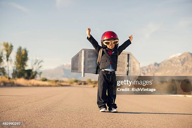 young boy wearing business suit and jet pack flies - unique stock pictures, royalty-free photos & images