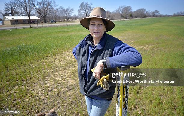 Julia Trigg Crawford leans on a TransCanada Keystone XL pipeline marker on her land in Direct, Texas.