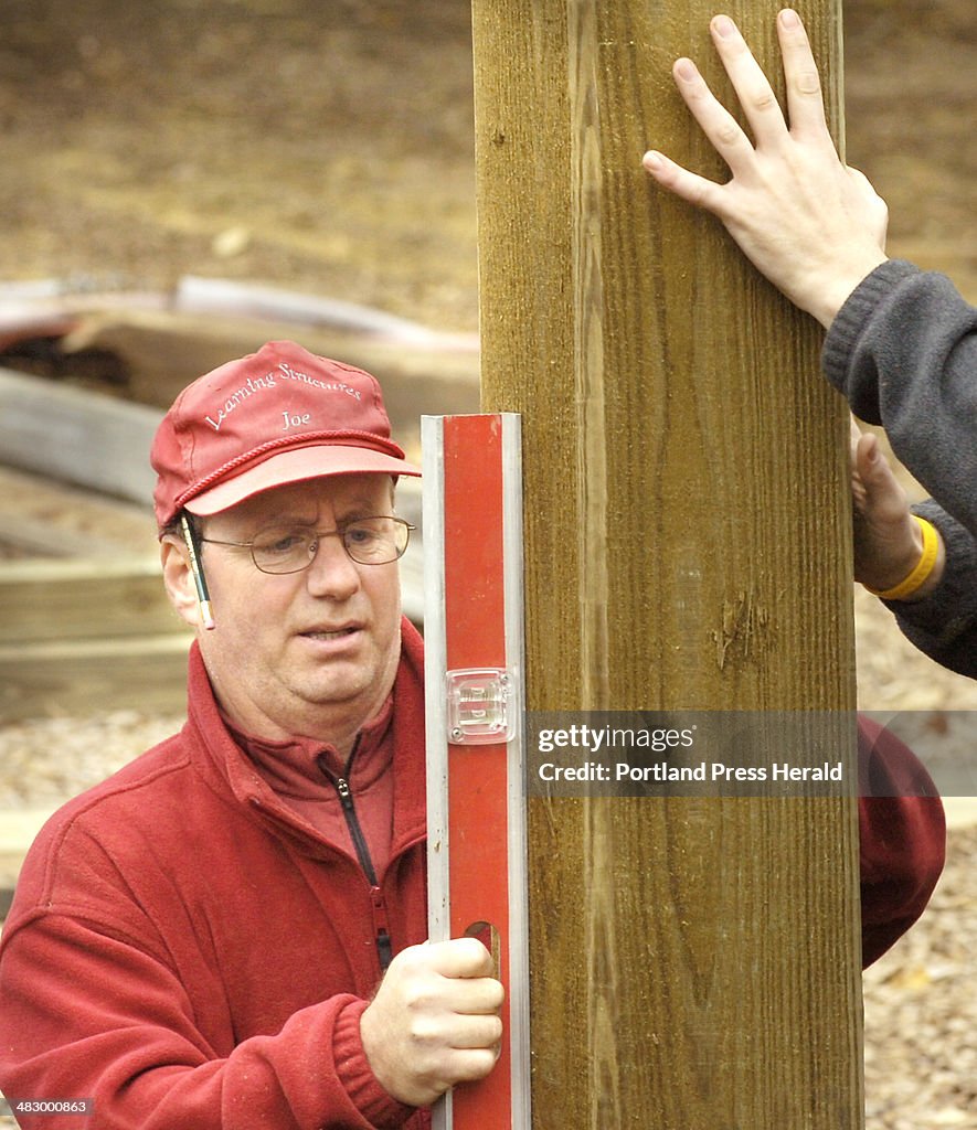Joe Cicirelli, from Learning Structures in Stratford, New Hampshire, checks the level of a beam in t