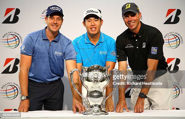 Henrik Stenson of Sweden, Byeong-Hun An of South Korea and Matt Kuchar of the USA pose with the trophy won by George Lyon of Canada at the 1904...