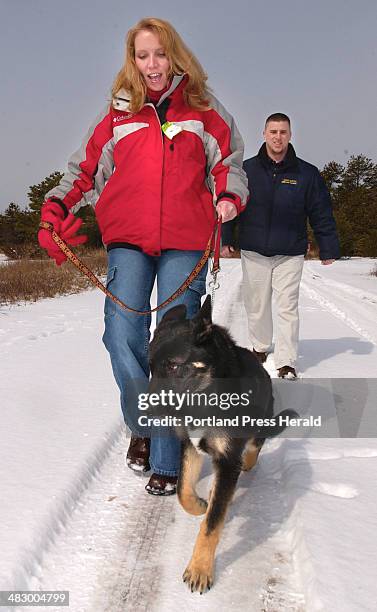 Staff Photo by Gordon Chibroski, Friday, March 19, 2004: Rob Pinkham, owner of Bark Busters, helps client, Kelli Howard learn how to keep her 5 month...