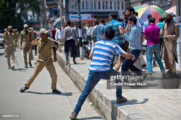 Indian police baton charge Kashmiri government teachers as they shout anti-government slogans atop a police vehicle during a protest against...