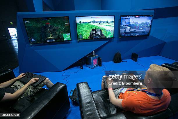 Gamers sit in armchairs and play computer games using Roccat Sova gaming board controllers at the Gamescom video games trade fair in Cologne,...