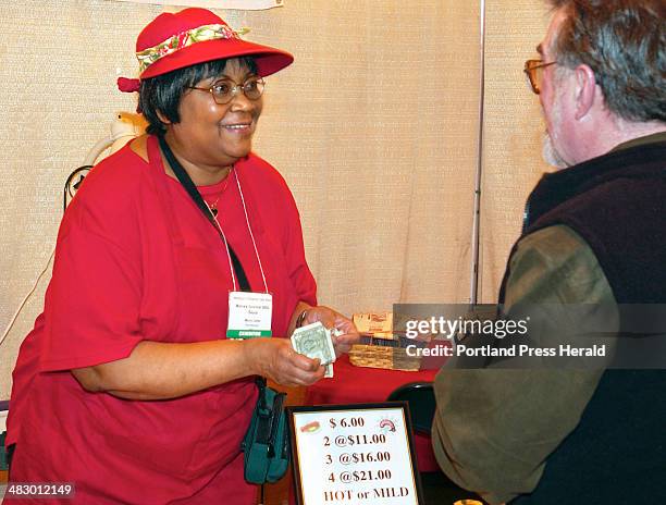 Staff Photo by Gordon Chibroski, Tuesday, March 9, 2004: Marva Carter sells a bottle of her special barbeque sauce to Vinny Gartmayer of Lubec who is...