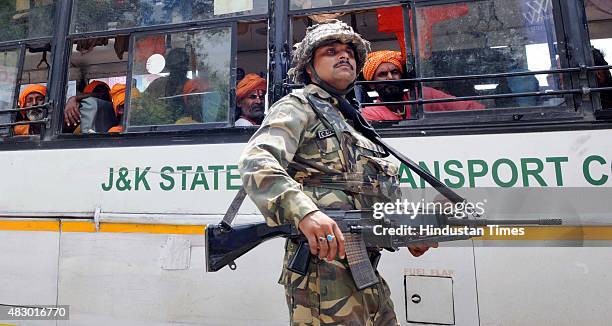 Soldier guards the bus carrying passengers of the Amarnath Yatra which was halted due to the terrorist attack on BSF convoy at Jammu-Srinagar...