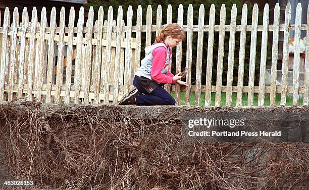 Staff Photo by Jill Brady, Thursday, April 22, 2004: Malichi Wyeth of Portland reattaches a board on a fence at a friend's house on the corner of...