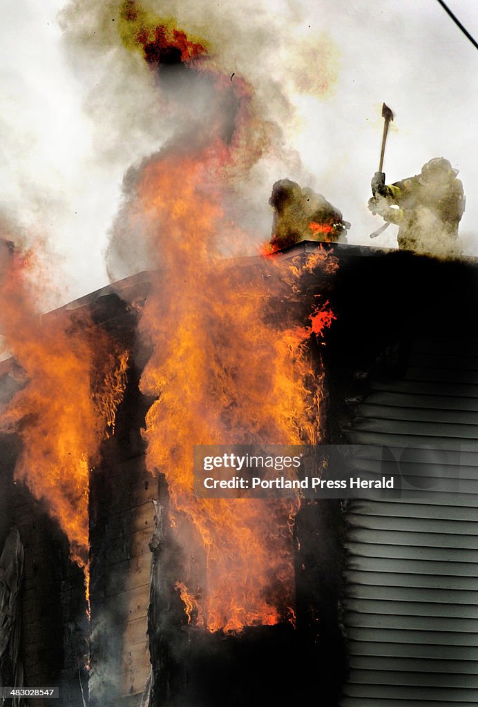Portland Fire fighters work the roof of a fully involved wooden 'triple decker' on Boynton St. Frida