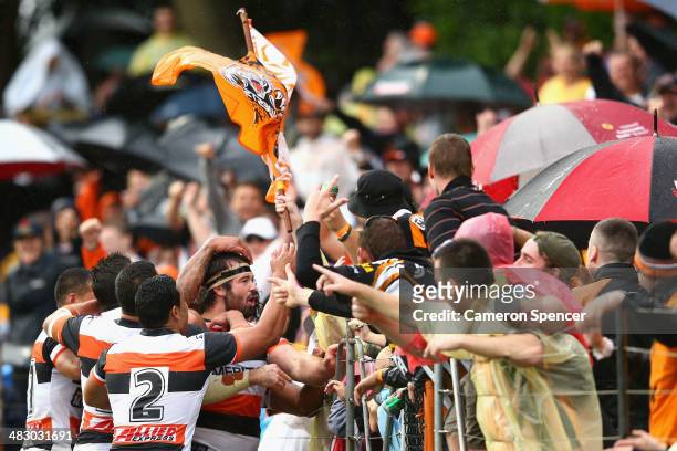 Aaron Woods of the Tigers celebrates with team mates after scoring a try during the round five NRL match between the Wests Tigers and the...
