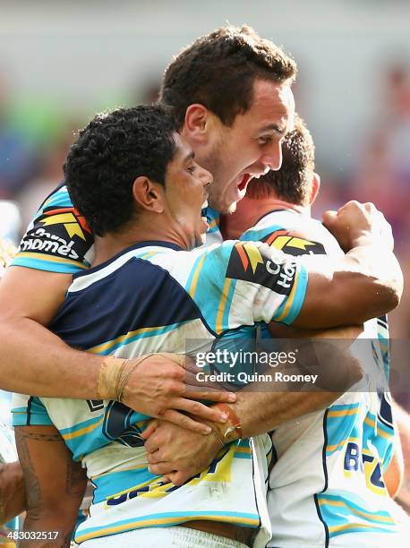 Mark Minichiello of the Titans is congratulated by Brad Takairangi and Albert Kelly after scoring a try during the round five NRL match between the...