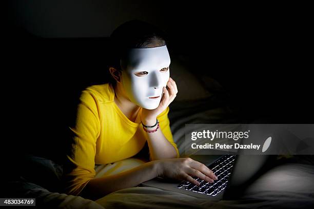 anonymous teenager in mask on internet at night - anonymous mask stockfoto's en -beelden