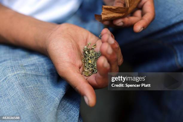 Man prepares to smoke K2 or "Spice", a synthetic marijuana drug, along a street in East Harlem on August 5, 2015 in New York City. New York, along...