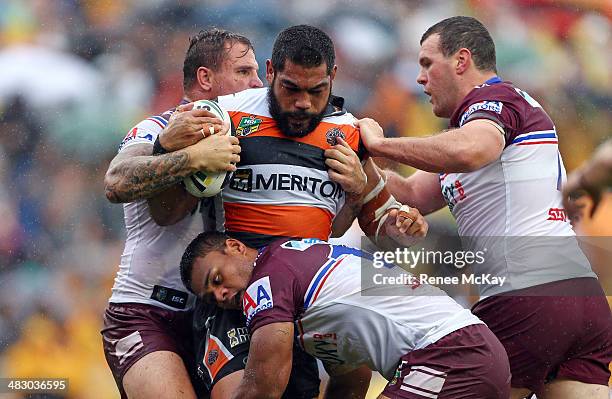 Adam Blair of the Tigers is tackled by Dunamis Lui, Anthony Watmough and Jason King during the round five NRL match between the Wests Tigers and the...